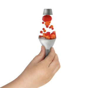 Hand hält Schylling Zabawka progresywna Lava Squish N'Flow mit roten und orangefarbenen Kugeln