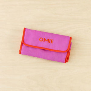 Lunchbag OmieTote – Pink faltbare Lunchbag von OMIE mit oranger Umrandung auf hellem Holzhintergrund