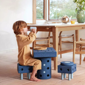 Kind sitzt auf Kreative Bausteine zur Förderung der Grobmotorik Dreamer Set – blau 25 in 1 als Tisch und Stuhl