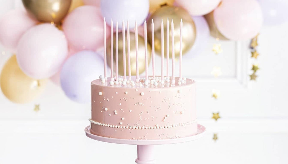 Elegante Torte mit speziellen Kerzen vor einer Luftballon-Dekoration für Ihre Partydeko und partyzubehör online kaufen.
