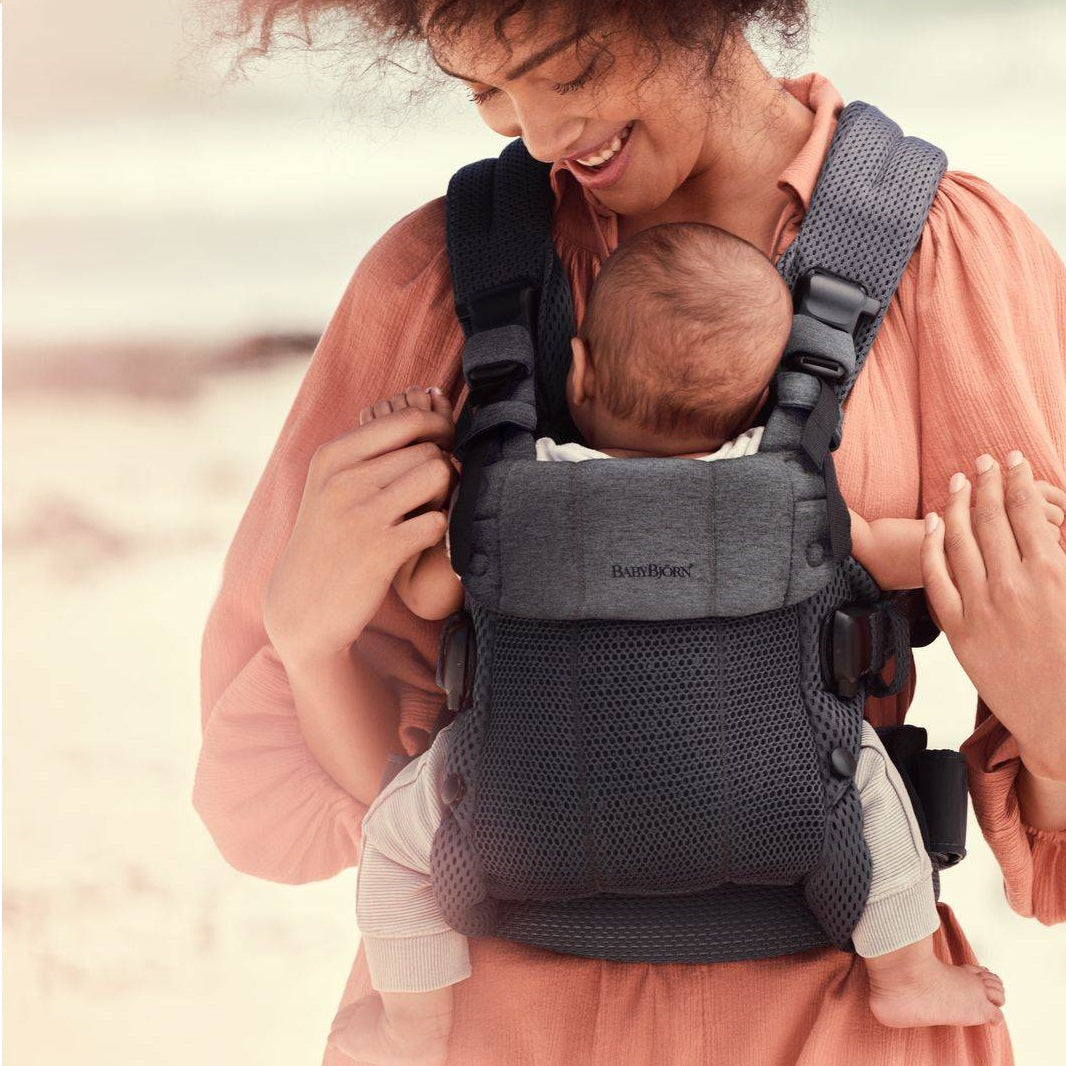 Mutter trägt Baby in ergonomischer Babytragen für Kinder mit atmungsaktivem Material und verstellbarem Design