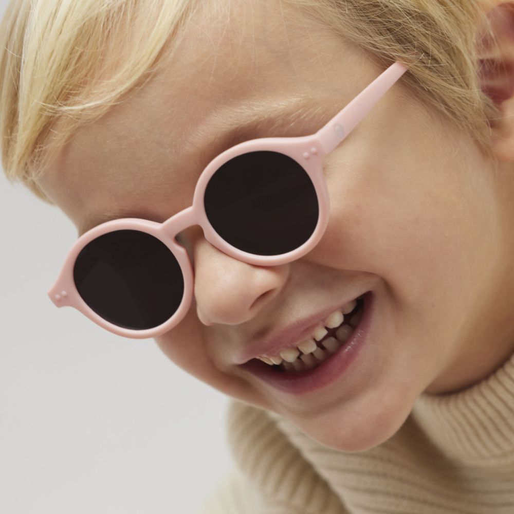 Kind trägt stylische rosa Sonnenbrillen für Kinder mit UV-Schutz und rundem Rahmen