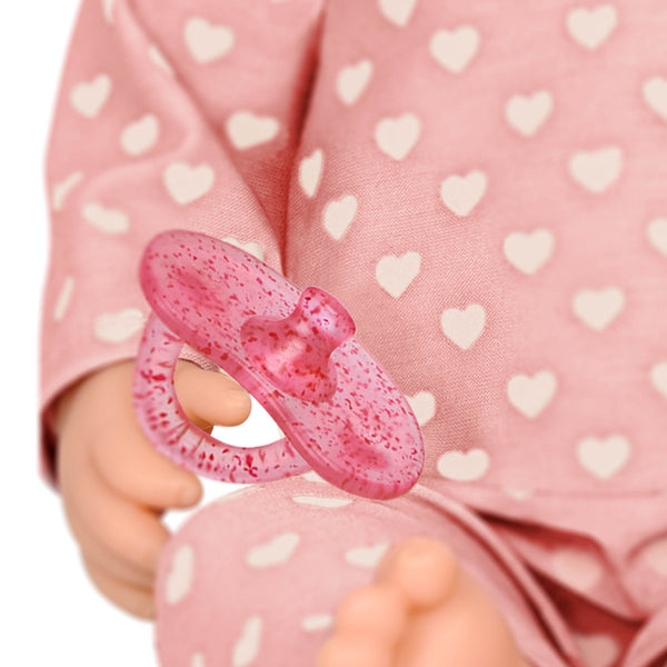 Babypuppe mit Schnuller im Pyjama mit Herzchen und Mütze