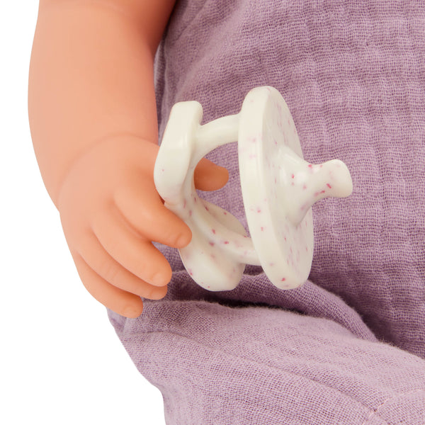 Babypuppe mit Schnuller im lila Musselinoutfit mit Stirnband