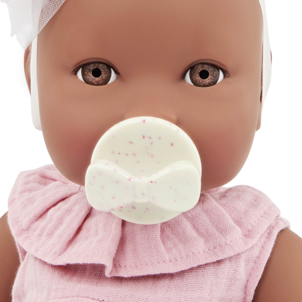 Babypuppe mit Schnuller im rosa Musselinoutfit mit Stirnband