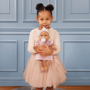 Babypuppe mit Schnuller im Kleid mit Stirnband