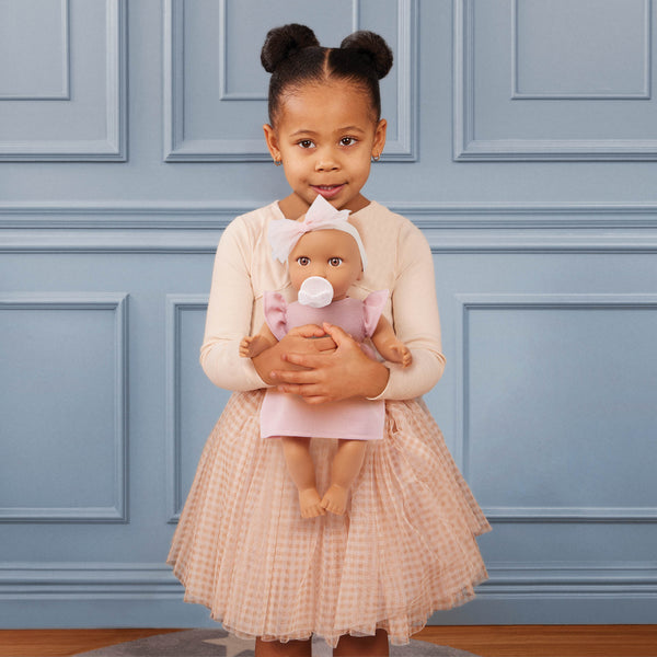 Babypuppe mit Schnuller im Kleid mit Stirnband