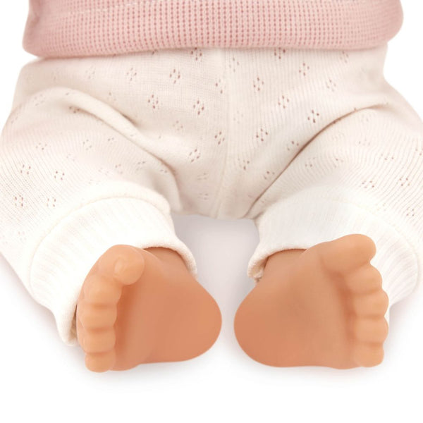 Babypuppe mit Haaren und Schnuller, in einem zweiteiligen Outfit