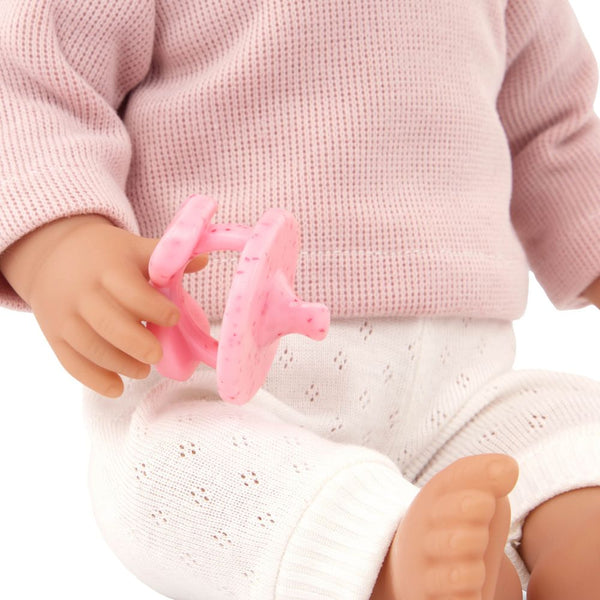 Babypuppe mit Haaren und Schnuller, in einem zweiteiligen Outfit