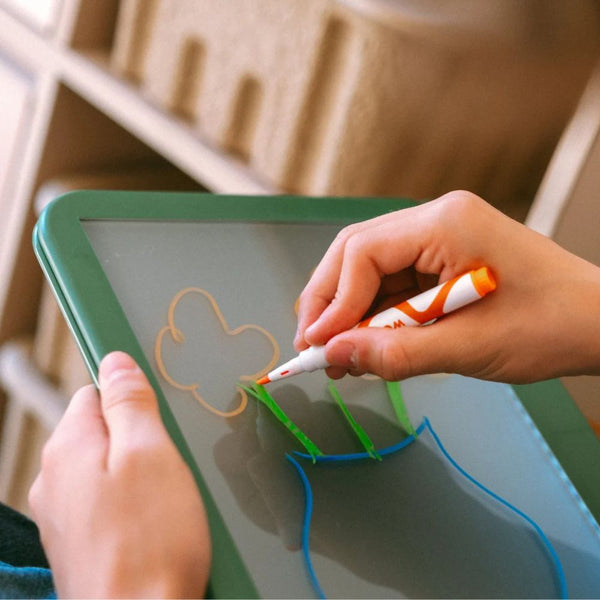 Kinderhand malt mit Neon-Kreidemarker eine Blume auf die Zeichentafel