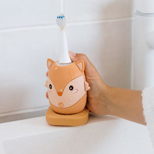 Hand stellt die Fuchs-Schallzahnbürste auf die Ladestation im Badezimmer