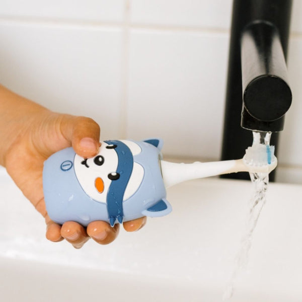 Waschbär-Schallzahnbürste wird unter dem Wasserhahn abgespült