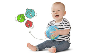 Lachendes Baby hält den Sensorik-Ball mit klingenden Glöckchen