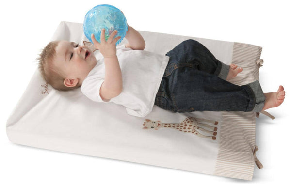 Baby liegt auf der Wickelauflage und hält den Sensorik-Ball hoch