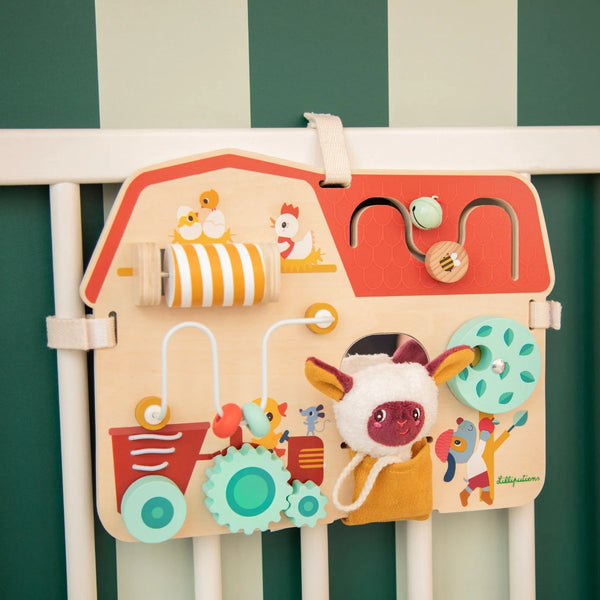 Activity-Board Bauernhof von Lilliputiens am Babybett befestigt