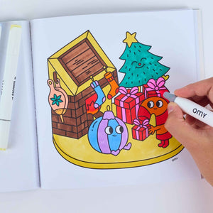 Kind malt ein weihnachtliches Motiv im Malbuch Cozy Art von OMY aus
