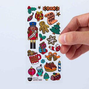 Stickerbogen Iconic Christmas von OMY mit Weihnachtsmotiven in der Hand