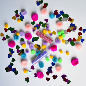 Bunte Bastelmaterialien von Apli Kids mit Pompons und herzförmigen Glitzerstücken für kreative Projekte