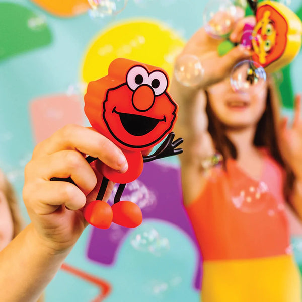 Badefigur Elmo – Set mit zwei im Wasser leuchtenden Sensorikwürfeln von Glo Pals gehalten von Kind