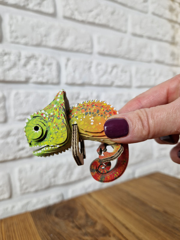 Händchen hält das 3D Öko-Puzzle Chamäleon aus Pappe mit lebendigen Farben und Details