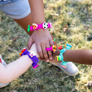Kinderhände mit bunt verzierten Armbändern und Ringen aus dem Schmuckset Plip Charms – Türkis von Fat Brain Toys