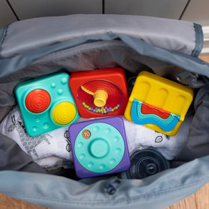 Fidget-Spielzeug von Fat Brain Toys in einer grauen Tasche mit bunten, stapelbaren Bausteinen