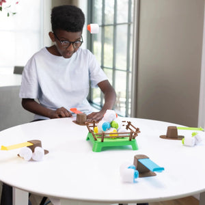 Fat Brain Toys Gra Spiel mit einem Jungen, der die bunten Elemente auf dem Tisch platziert