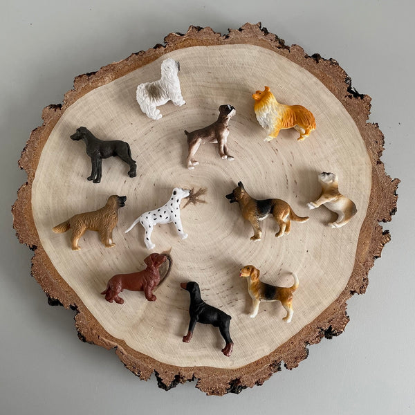 Hunde Spielfiguren Set mit 10 detailreichen Plastikfiguren verschiedener Hunderassen auf Holzscheibe