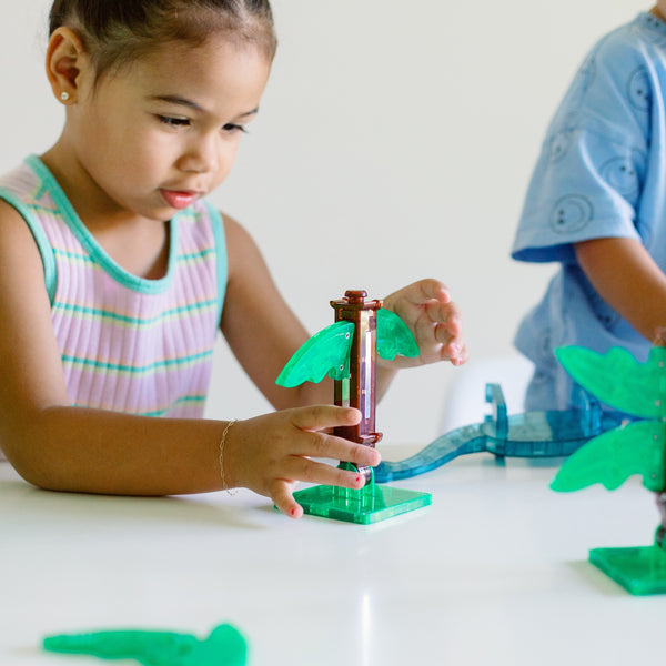 Kinder spielen mit Magnetbausteine Dino World XL und bauen bunte Dinosaurier-Szenen