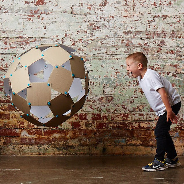 Makedo Zestaw konstrukcyjny mit Ball aus verbundenen Pappstücken, spielendes Kind im weißen T-Shirt