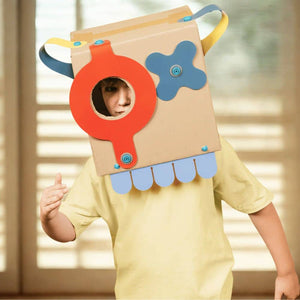 Kind mit Makedo kreativem Formenset für Kinder, trägt eine fantasievolle Box mit bunten Formen.