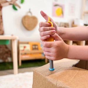 Kinderhände benutzen Schraubenzieher aus dem Schraubensatz für DIY-Konstruktionen – SCRU COMBO 160 Teile von Makedo