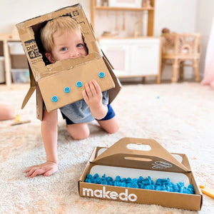 Kind spielt mit Makedo Werkzeugset und sicherer Kartonperforierroller Fold-Roller aus Karton