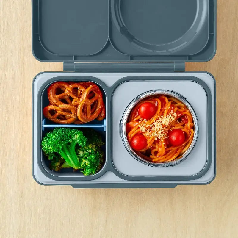 Lunchbox mit Thermosbehälter OmieBox Up – Graphite von OMIE geöffnet mit verschiedenen Snacks und Thermosbehälter mit Nudeln