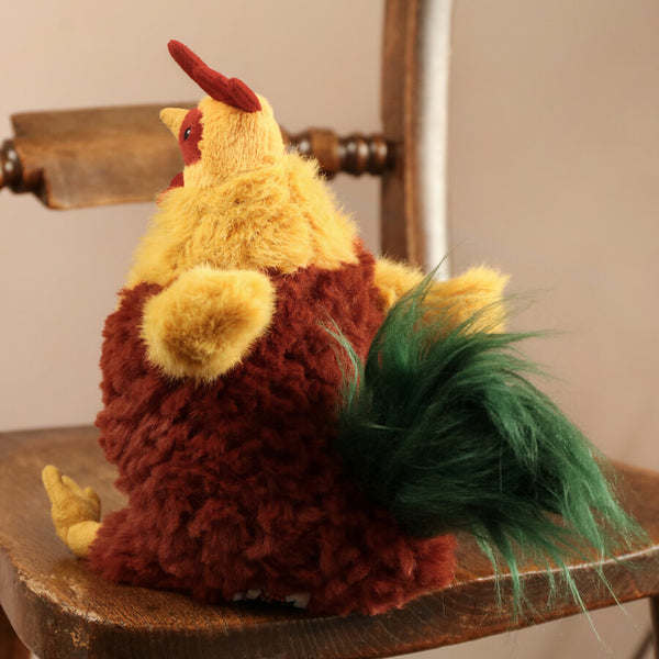 Jellycat Plüsch-Hahn 22 cm sitzend mit weichem braunem und gelbem Fell und grünem Schwanz