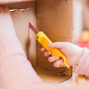 Kind benutzt sichere Säge Safe-Saw von Makedo zum Schneiden von Karton spielerisch und sicher