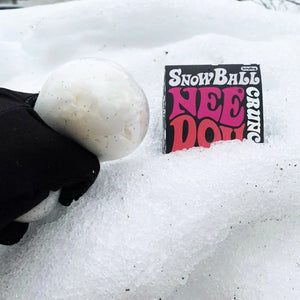 Schylling Snow Ball Crunch NeeDoh Spielzeug in Form einer weißen Kugel im Schnee