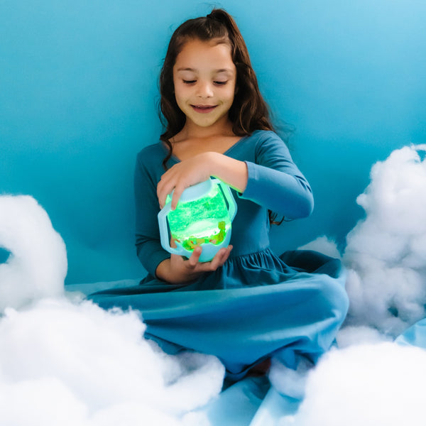 Mädchen spielt mit Glo Pals Zabawka progresywna Sensorik-Glas zum Befüllen mit Wasser hellblau