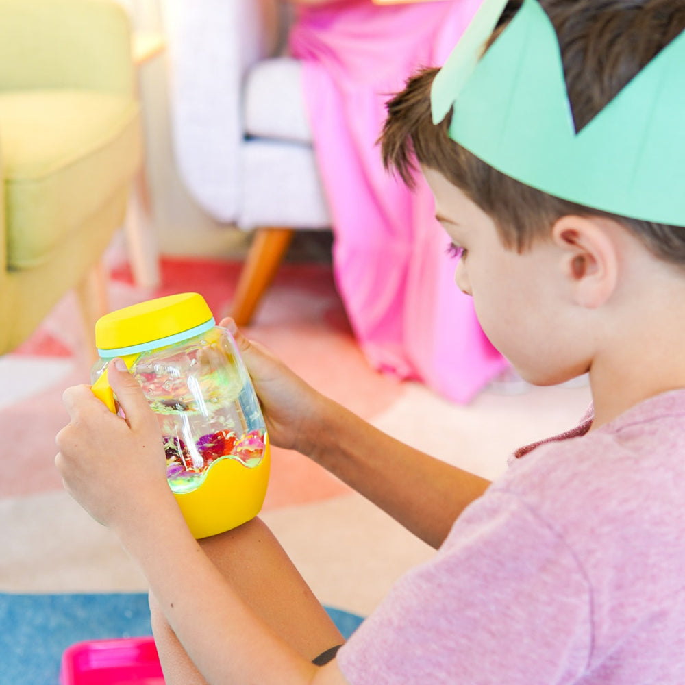 Zabawka progresywna von Glo Pals mit leuchtendem Sensorik-Glas zum Befüllen mit Wasser – gelb, spielende Kinder