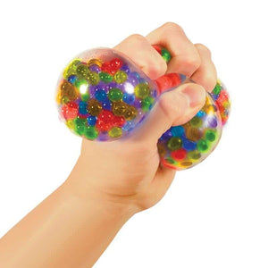 Hand hält bunten Sensorischer Knetball Squeezy Peezy mit farbigen Perlen innen zum Drücken