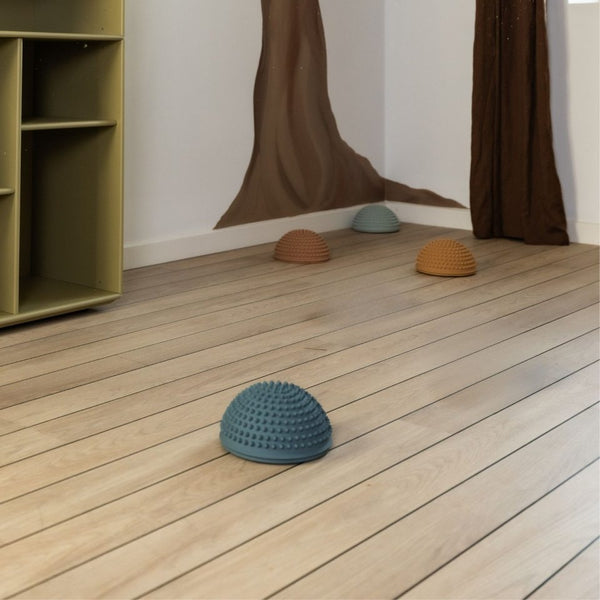 Sensorischer Parcours Sonnenuntergang mit rauen Balancesteinen auf Holzfußboden in Kinderzimmer
