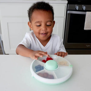 Kind benutzt den Snack Spinner Snackbehälter - Macaron Blue von Gobe mit mehreren Fächern für Snacks