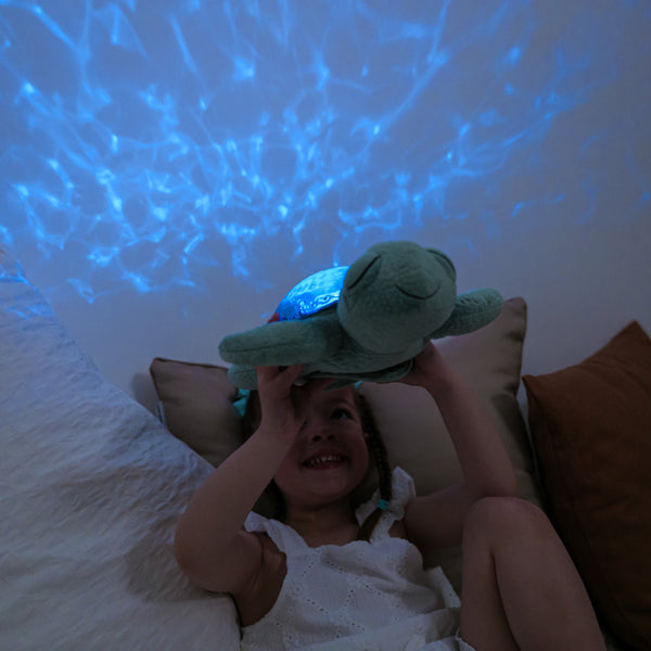 Tranquil Turtle Spieluhr Projektor mit sanften Lichtern und einem lächelnden Kind auf einem Bett